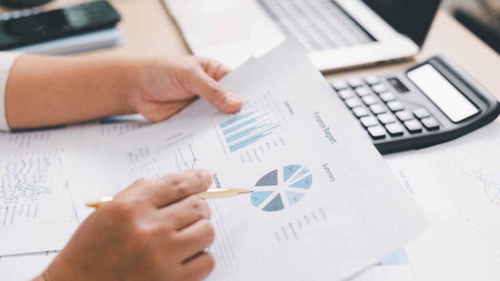 report behind held and reviewed in detail by a person at a desk.